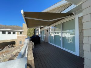 Residential retractable awning providing shade on deck in Minnesota